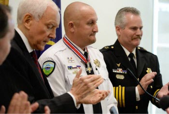 Senators Mike Lee, Orrin Hatch, and Sheriff Terry Thompson, at right, present Lt. Nathan Hutchinson, in white, with the State and Local Law Enforcement Congressional Badge of Bravery Award. (Photo credit: Francisco Kjolseth, The Salt Lake Tribune).